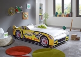 gelbes Relita Rennwagenbett in Kinderzimmer mit Teppichen und offenem Fenster